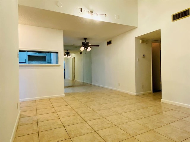 empty room with light tile patterned flooring and ceiling fan