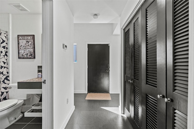 hall featuring dark tile patterned floors