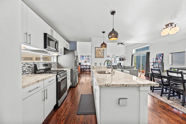 kitchen with sink, white cabinetry, stainless steel appliances, and hanging light fixtures