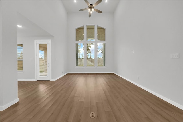 unfurnished living room featuring ceiling fan, a healthy amount of sunlight, and wood-type flooring