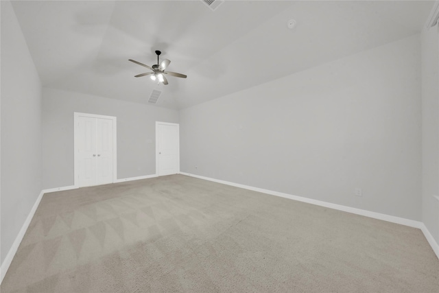 empty room featuring light colored carpet, vaulted ceiling, and ceiling fan