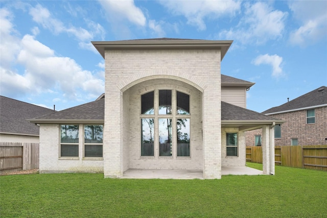 rear view of property with a lawn and a patio