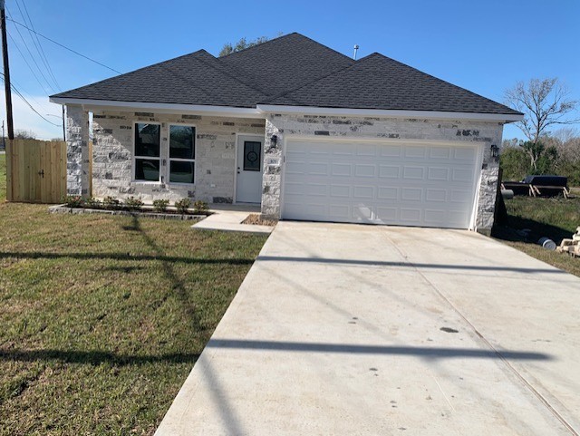 view of front of house with a garage and a front lawn