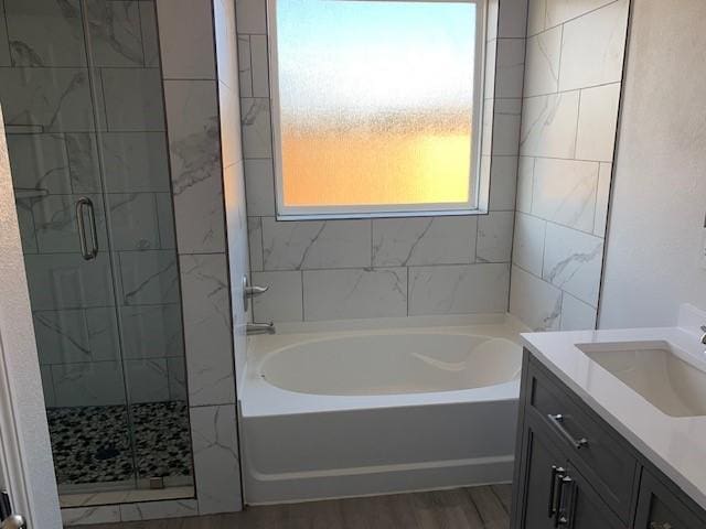 bathroom featuring independent shower and bath, vanity, and wood-type flooring