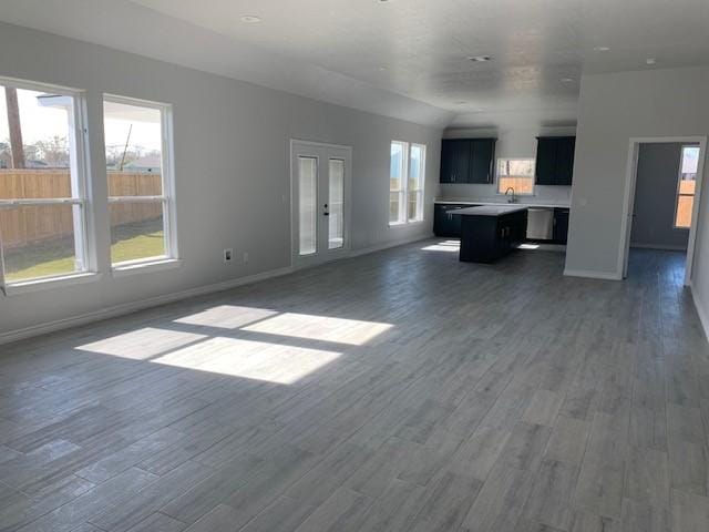 unfurnished living room with dark hardwood / wood-style floors and vaulted ceiling