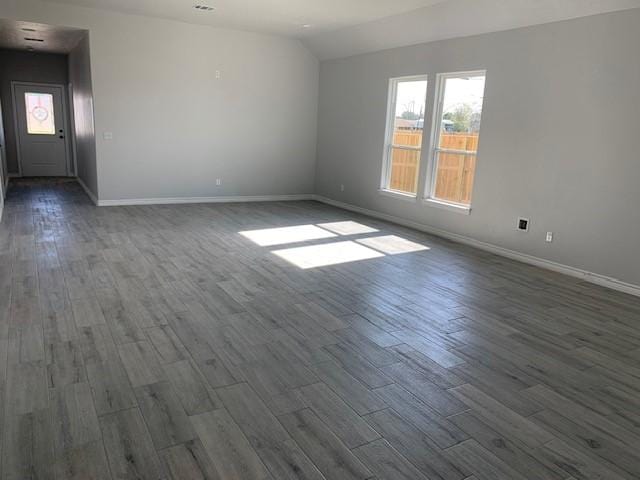 empty room with dark hardwood / wood-style flooring and lofted ceiling