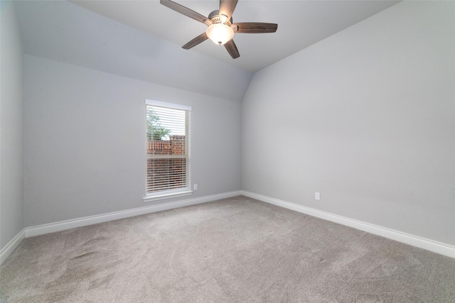 carpeted empty room featuring vaulted ceiling and ceiling fan