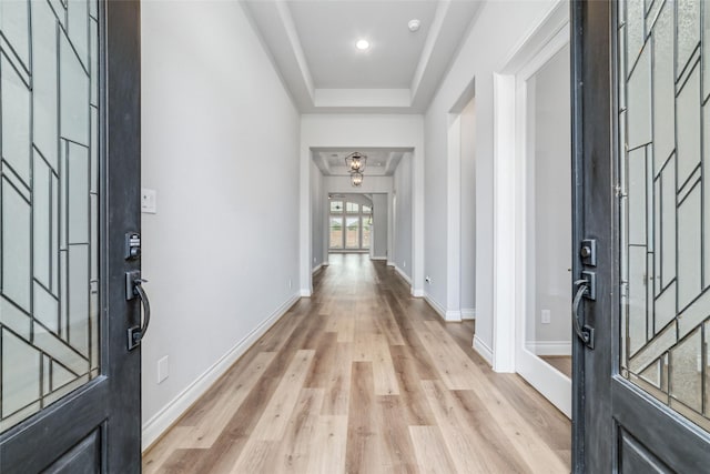 entrance foyer featuring a tray ceiling and light wood-type flooring