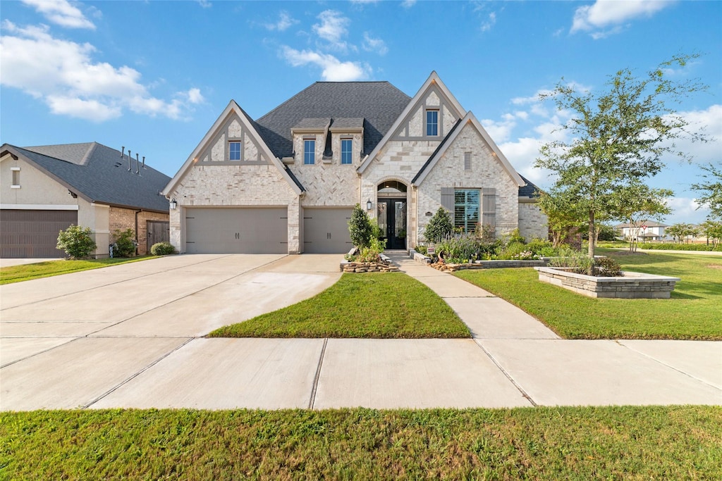 view of front of property with a garage and a front lawn