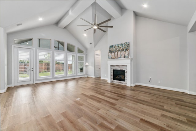 unfurnished living room with high vaulted ceiling, a fireplace, ceiling fan, light hardwood / wood-style floors, and beam ceiling