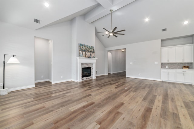 unfurnished living room featuring ceiling fan, a fireplace, and light hardwood / wood-style flooring