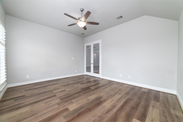 empty room with vaulted ceiling, dark hardwood / wood-style floors, ceiling fan, and french doors