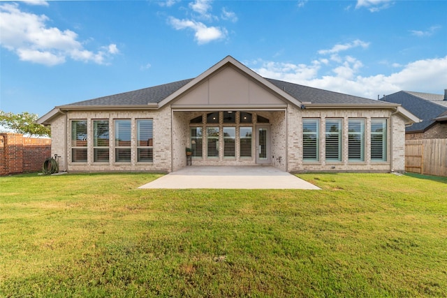 rear view of property featuring a patio area and a lawn