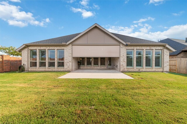 back of house featuring a patio area and a lawn