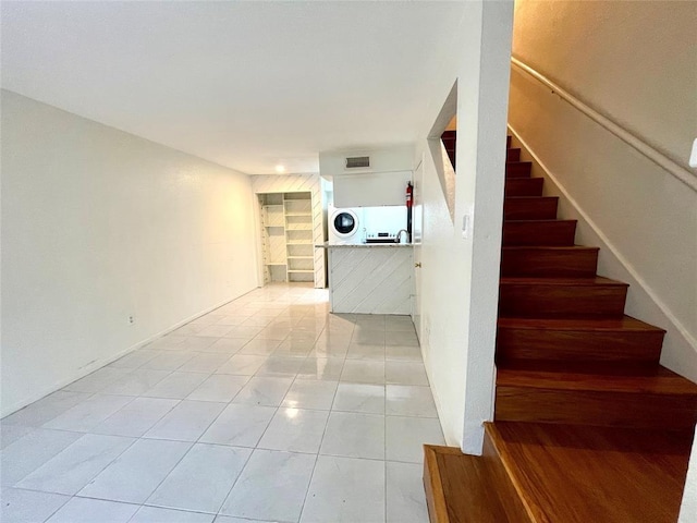 staircase with washer / clothes dryer and tile patterned flooring