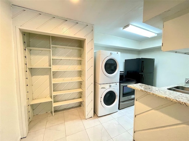 laundry room featuring sink and stacked washer / dryer