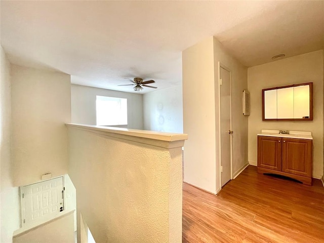 hallway featuring sink and light hardwood / wood-style floors