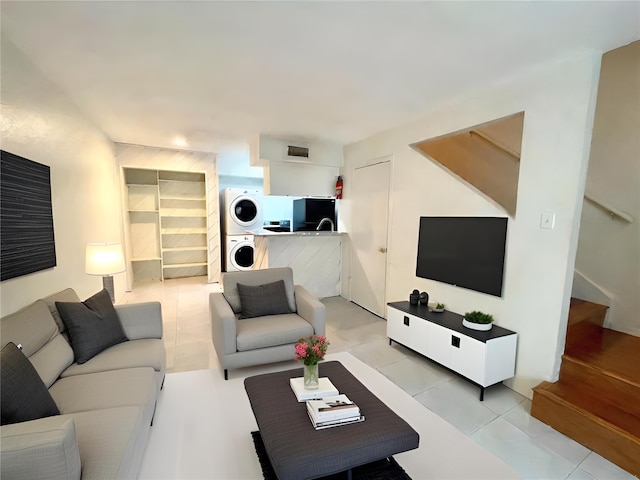 living room with stacked washer / drying machine and light tile patterned floors