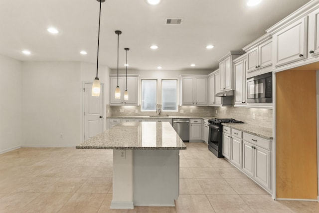 kitchen featuring black appliances, hanging light fixtures, light stone countertops, a kitchen island, and white cabinetry