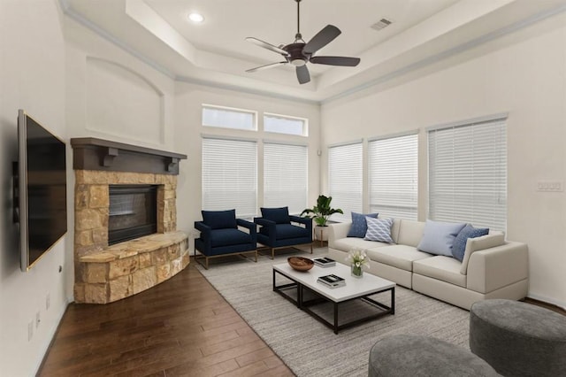 19622 Chaparral Berry Dr, Cypress, TX 77433 - living area featuring hardwood / wood-style floors, a ceiling fan, a stone fireplace, a tray ceiling, and recessed lighting