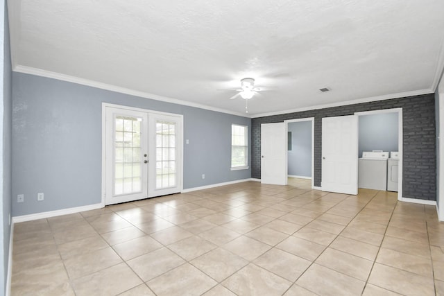 spare room featuring french doors, washer and dryer, brick wall, and ornamental molding