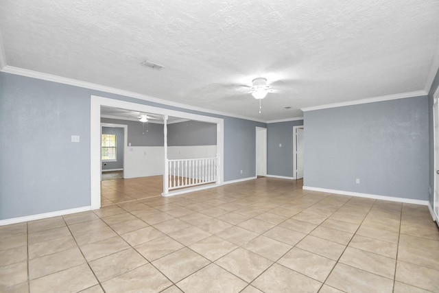 empty room with light tile patterned floors, a textured ceiling, and crown molding