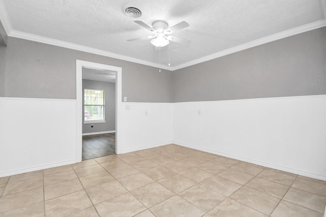 tiled empty room featuring a textured ceiling, ceiling fan, and crown molding