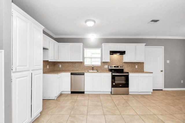 kitchen featuring white cabinets, ornamental molding, light tile patterned flooring, light stone counters, and stainless steel appliances