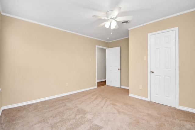 unfurnished bedroom with ceiling fan, light colored carpet, and ornamental molding