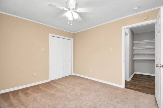 unfurnished bedroom with ceiling fan, light colored carpet, ornamental molding, and a closet