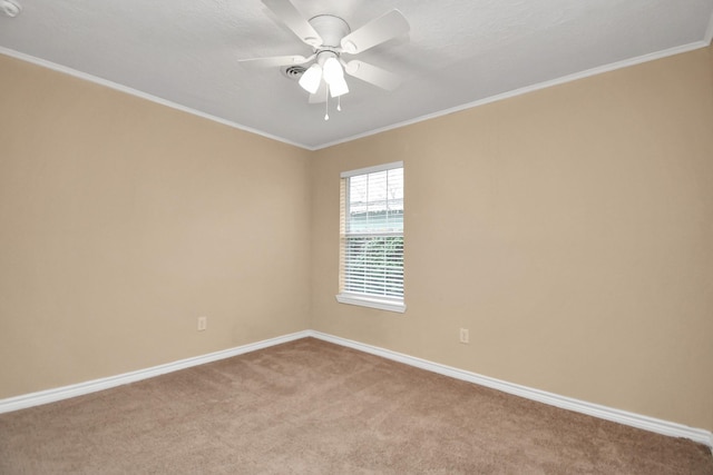 empty room featuring ceiling fan, crown molding, and light carpet