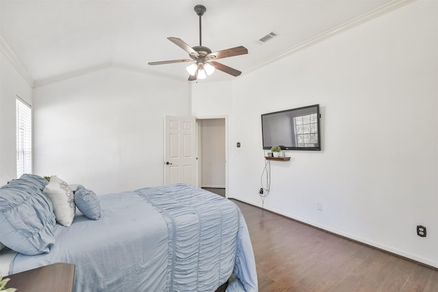 bedroom with lofted ceiling, crown molding, dark hardwood / wood-style flooring, and ceiling fan