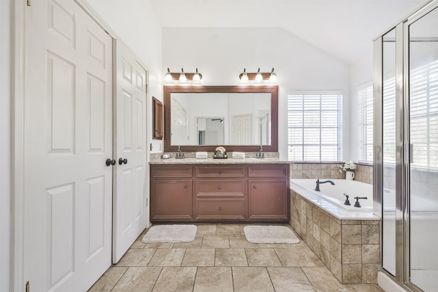 bathroom featuring independent shower and bath, vanity, and lofted ceiling