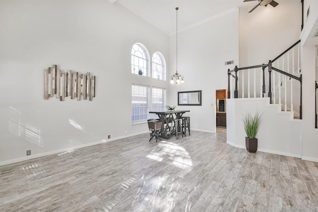 living room with ceiling fan with notable chandelier, beamed ceiling, high vaulted ceiling, and light wood-type flooring