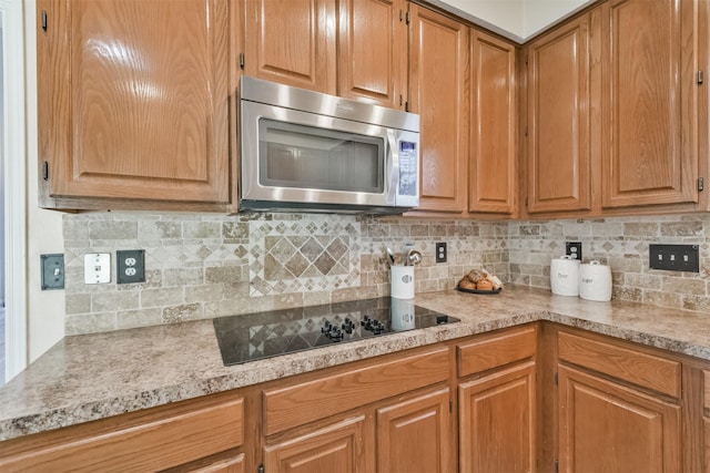 kitchen with tasteful backsplash and black electric cooktop