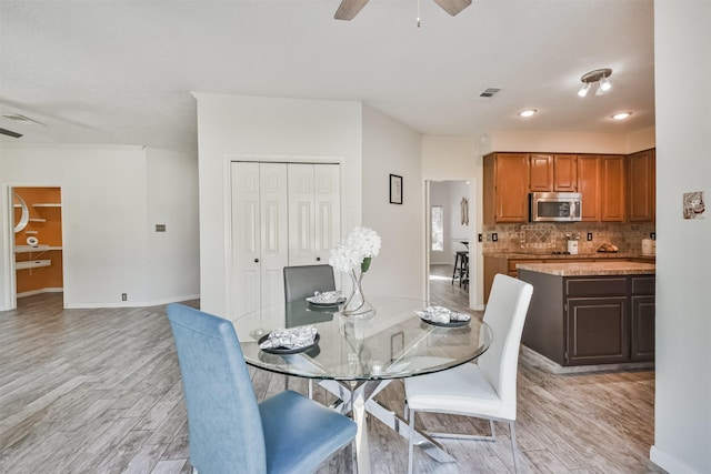 dining area with ceiling fan and light hardwood / wood-style floors