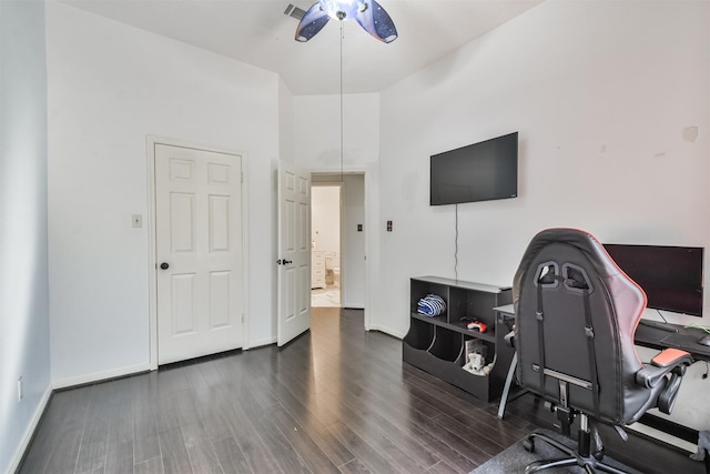 office space featuring ceiling fan, a towering ceiling, and dark hardwood / wood-style flooring