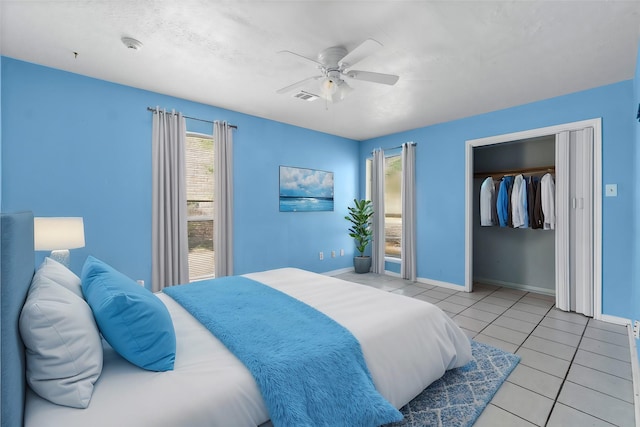 bedroom with light tile patterned floors, a closet, and ceiling fan