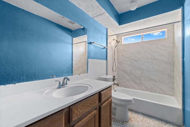 full bathroom with toilet, vanity, and tiled shower / bath