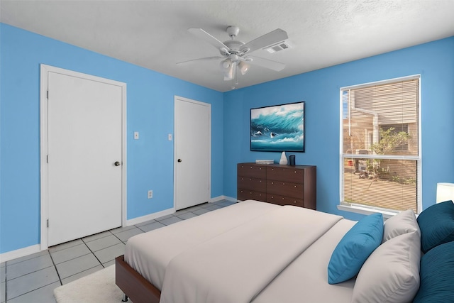 bedroom featuring light tile patterned floors, a textured ceiling, and ceiling fan