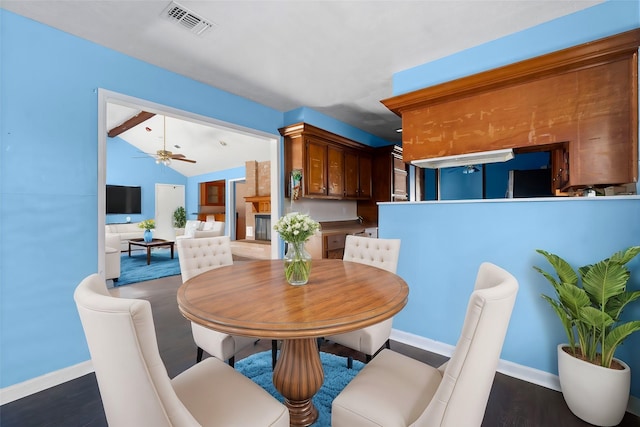 dining room featuring lofted ceiling with beams, dark hardwood / wood-style floors, and ceiling fan