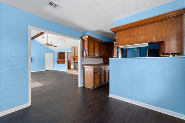 kitchen with vaulted ceiling with beams, ceiling fan, and dark hardwood / wood-style floors