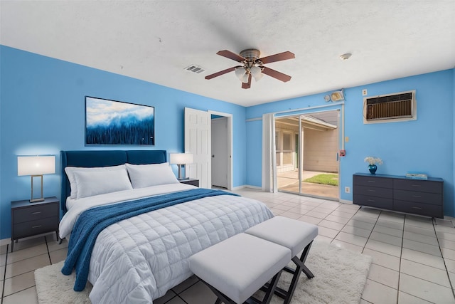 tiled bedroom featuring access to exterior, a textured ceiling, a wall mounted AC, and ceiling fan