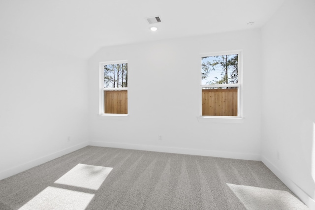 empty room with carpet floors and vaulted ceiling