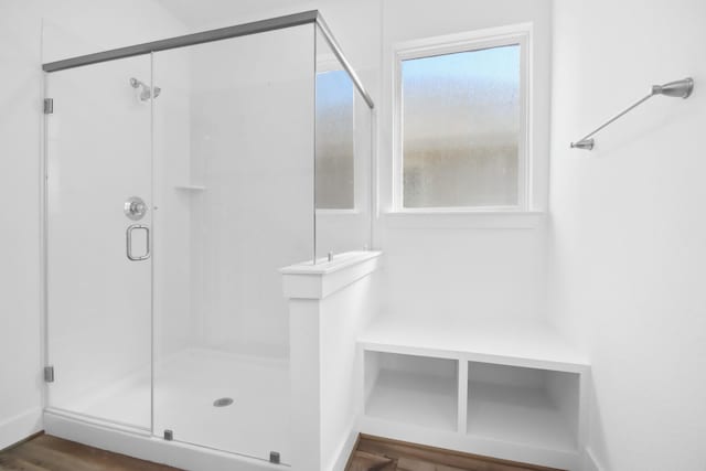 bathroom featuring a wealth of natural light, hardwood / wood-style flooring, and walk in shower