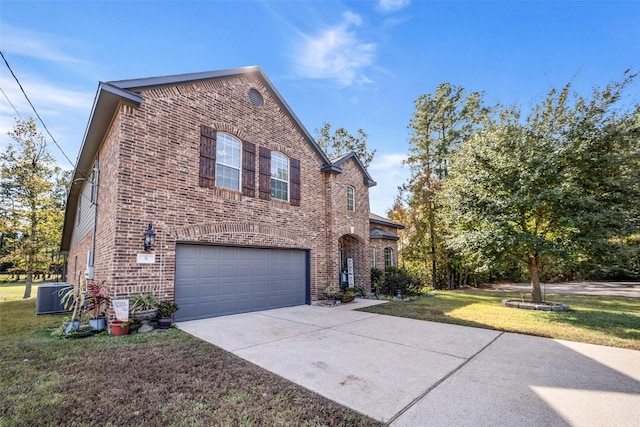 view of front of home featuring a front yard, central AC unit, and a garage