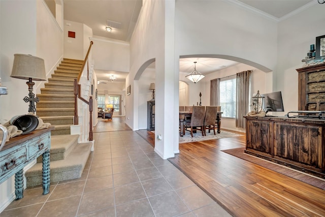 foyer entrance featuring light tile patterned floors and ornamental molding