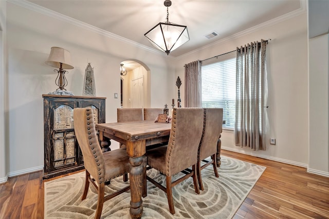 dining room featuring light wood-type flooring and crown molding