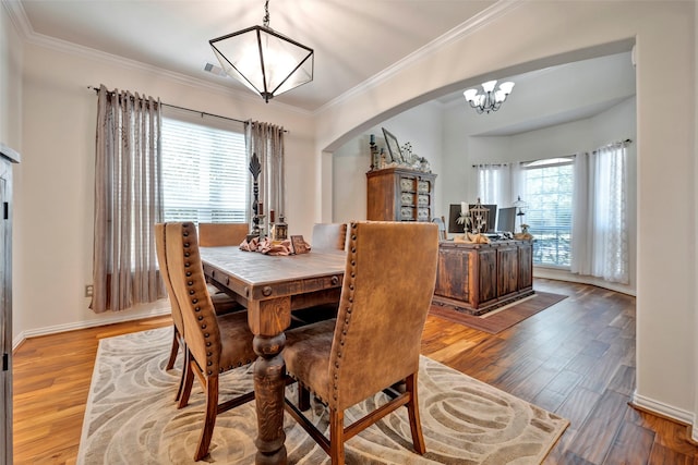 dining room featuring light wood-type flooring, plenty of natural light, and ornamental molding