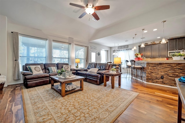 living room featuring ceiling fan and light hardwood / wood-style flooring